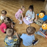 #FunduszeUE  #FunduszeEuropejskie Grupa dzieci ogląda książkę Mała spóźnialska.jpg