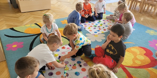 dzieci w grupach segregują kolorowe kuleczki .jpg