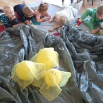 Dzieci leżą wokół foli i balonów.jpg