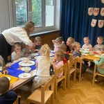 Grupa dzieci podczas śniadania pełnego uśmiechów.jpg