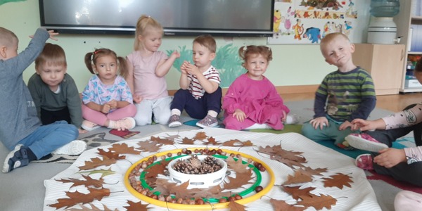 Dzieci siedzą  wokół jesiennej mandali.jpg