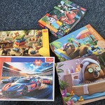 Pięć opakowań puzzli.