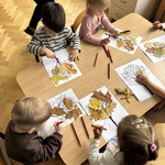 zdj. 5 Dzieci wykonują pracę plastyczną - przyklejają liście na kontur drzewa.jpeg