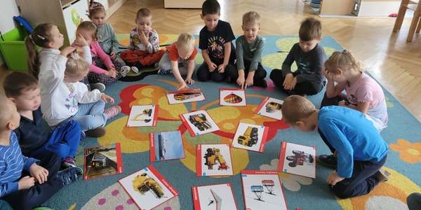 dzieci oglądają ilustracje różnych pojazdów .jpg