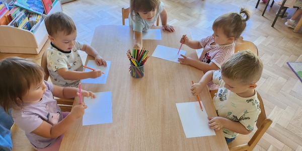 Dzieci rysują przy stoliku