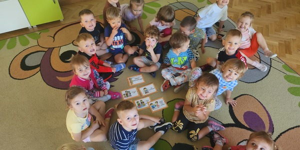 Grupa dzieci na dywanie układa karty obrazkowe