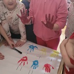 dziewczynka prezentuje na dłoniach jaki kolor powstał po zmieszaniu koloru czerwonego i niebieskiego.jpg