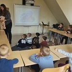 dzieci siedzą i słuchają lektorki języka angielskiego z misiem w ręku.jpg
