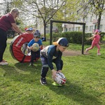 dzieci przechodzą przez koło z piłką do rugby.jpg