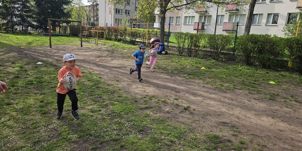dzieci biegną trzymając piłkę do rugby.jpg