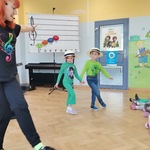 Grupa dzieci tańczy z prowadzącą audycje muzyczną. (2).jpg
