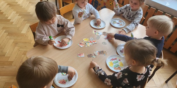 dzieci wykonują pracę plastyczną - zdrowy talerz (przyklejają gotowe elementy do papierowego talerzyka) (2).jpg